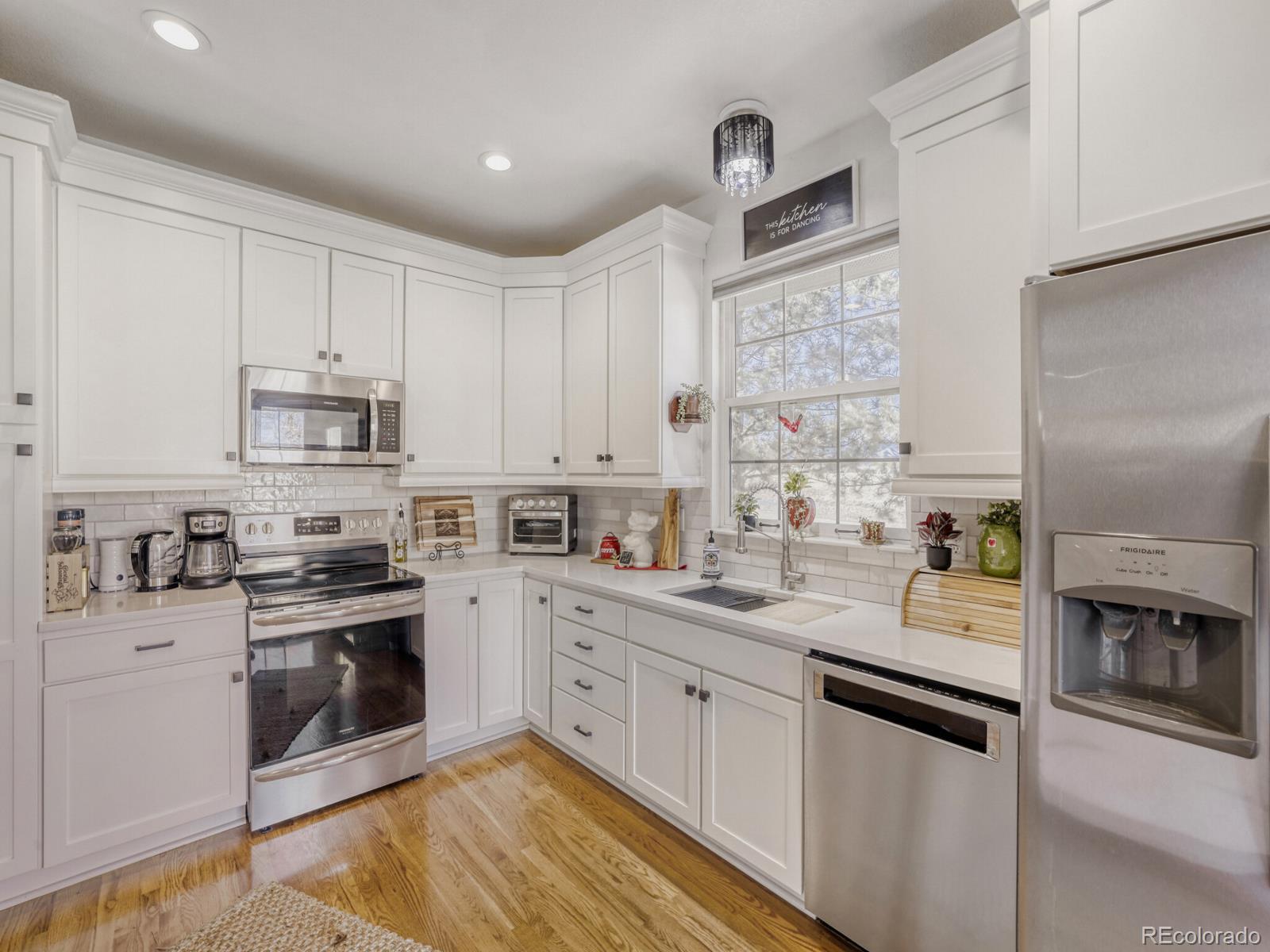 8893 Tappy Toorie Circle Highlands Ranch, CO 80129 - Photo 9 of 36 a kitchen with stainless steel appliances granite countertop a stove a sink and a refrigerator