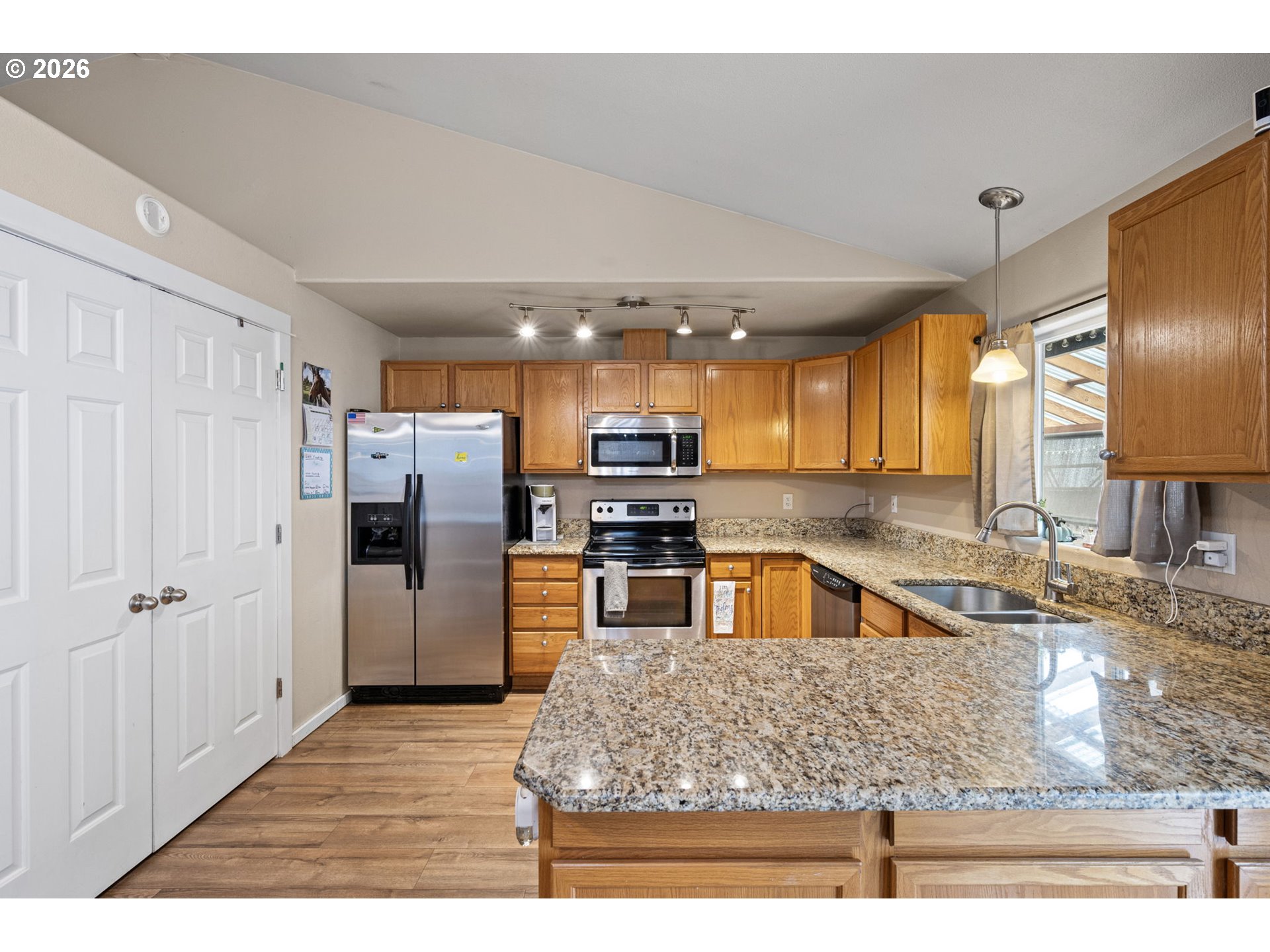 1055 Ash Grove Loop Creswell, OR 97426 - Photo 13 of 33 a kitchen with stainless steel appliances granite countertop a sink and a refrigerator
