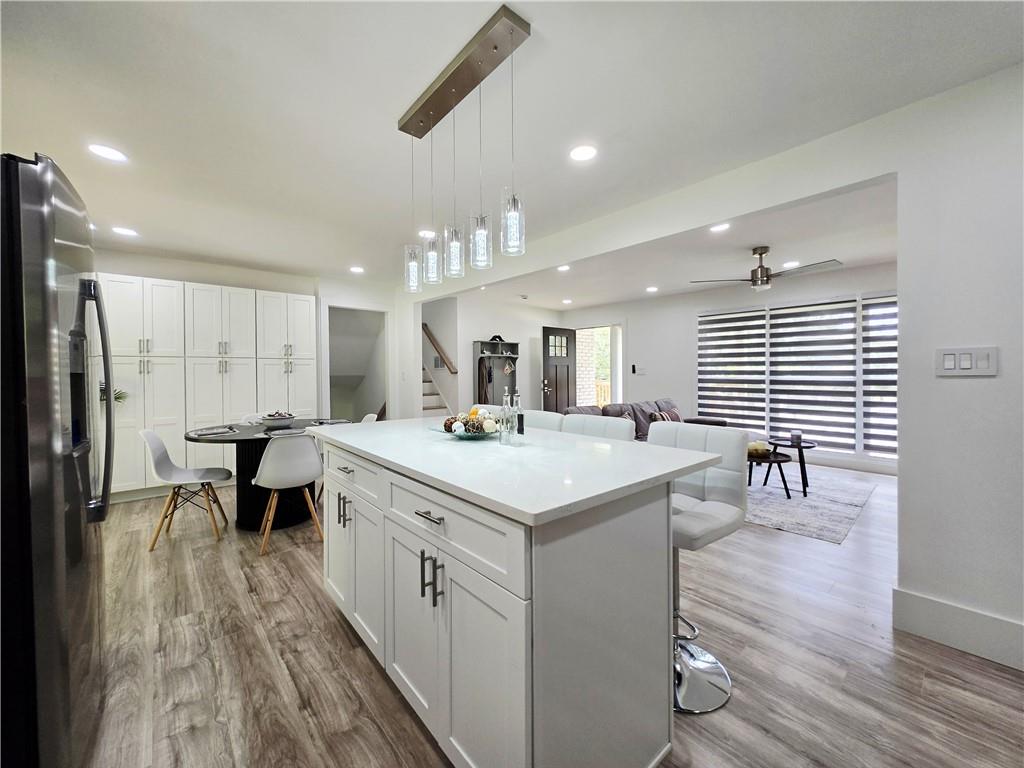 2400 Glenrock Drive Decatur, GA 30032 - Photo 12 of 39 a large kitchen with kitchen island a sink dishwasher a dining table and chairs with wooden floor