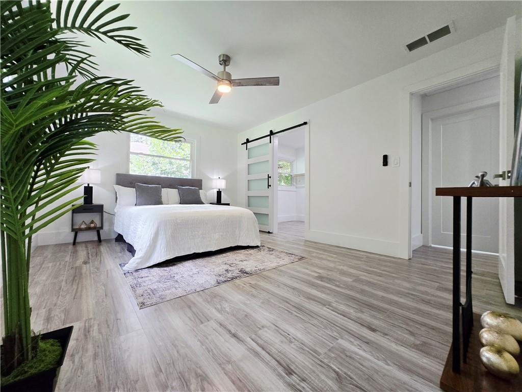 2400 Glenrock Drive Decatur, GA 30032 - Photo 18 of 39 a bedroom with a bed and a large mirror with wooden floor