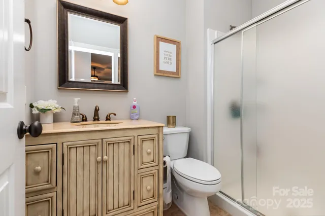a bathroom with a granite countertop toilet sink and mirror