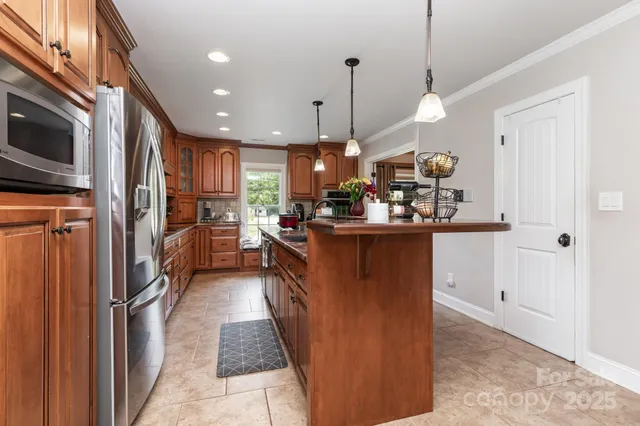 a kitchen with stainless steel appliances granite countertop a refrigerator a oven a sink and a stove