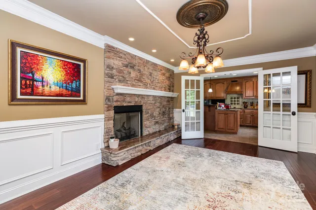 a living room with furniture a fireplace and a chandelier