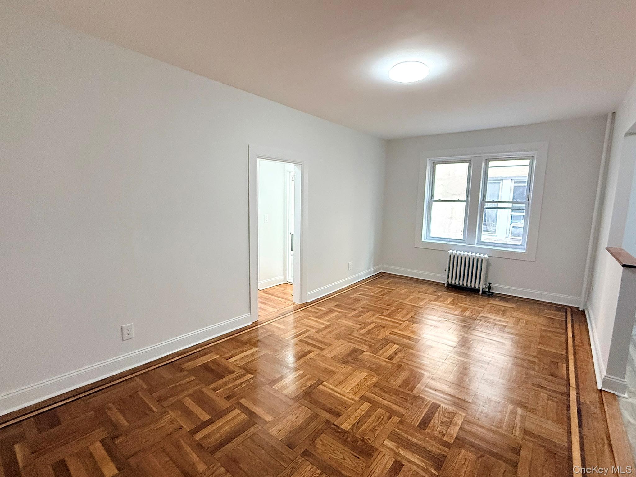 47-48 43rd Street, Unit 2F Queens, NY 11377 - Photo 11 of 29 an empty room with wooden floor and windows