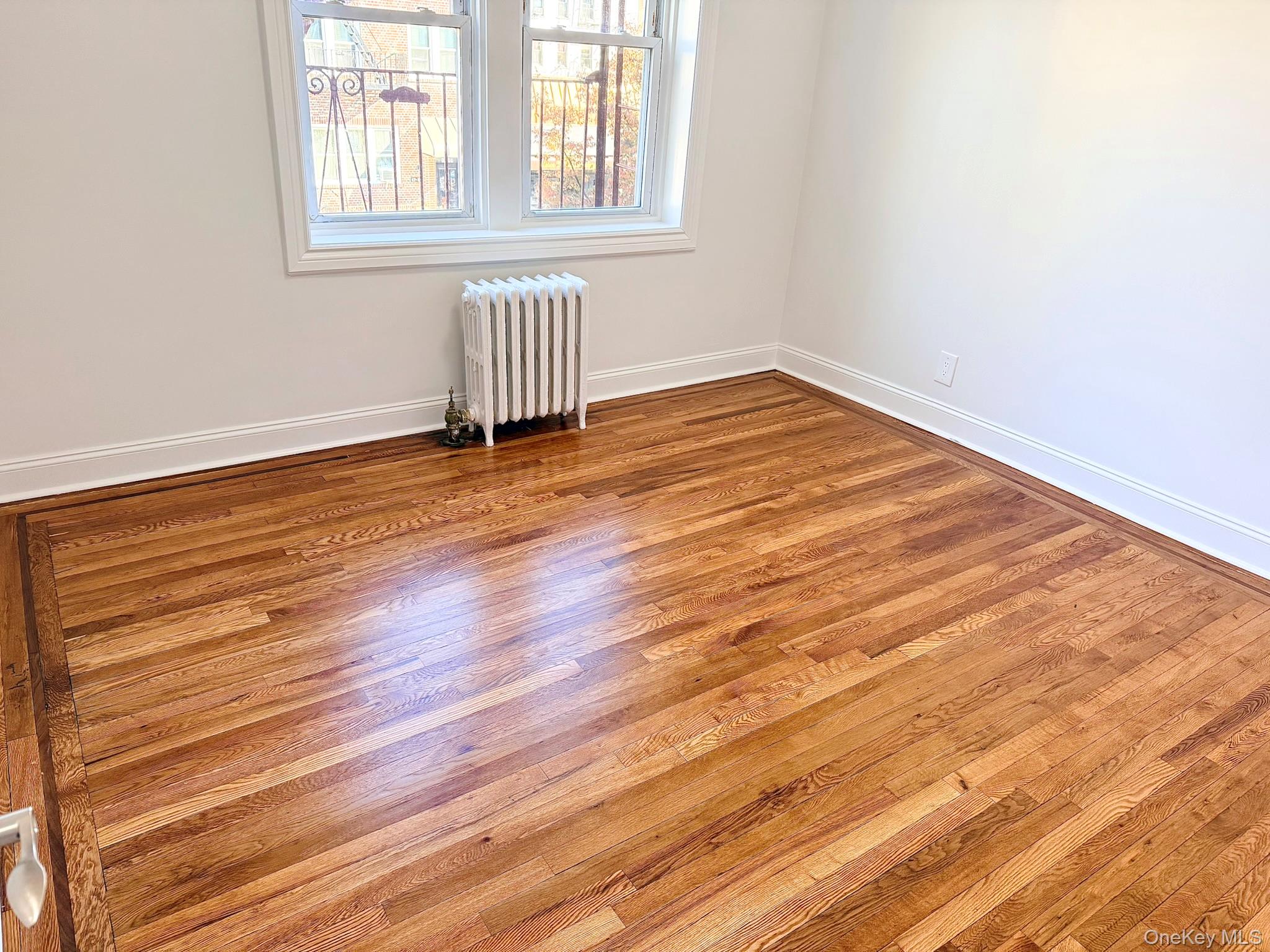 47-48 43rd Street, Unit 2F Queens, NY 11377 - Photo 19 of 29 an empty room with wooden floor and windows