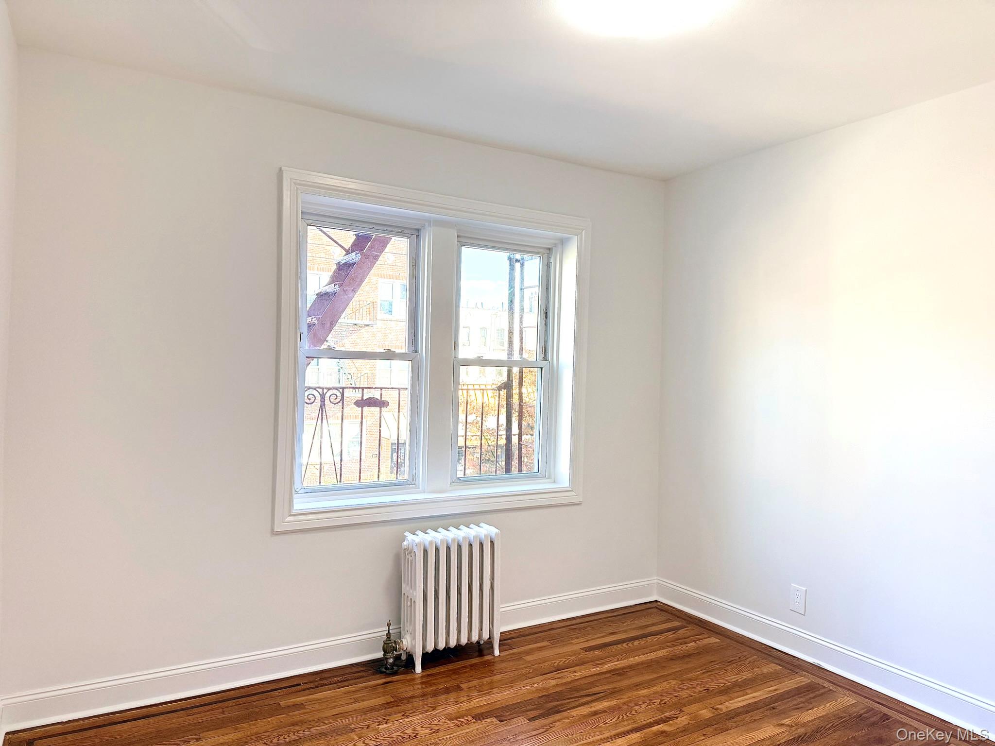 47-48 43rd Street, Unit 2F Queens, NY 11377 - Photo 21 of 29 an empty room with wooden floor and windows