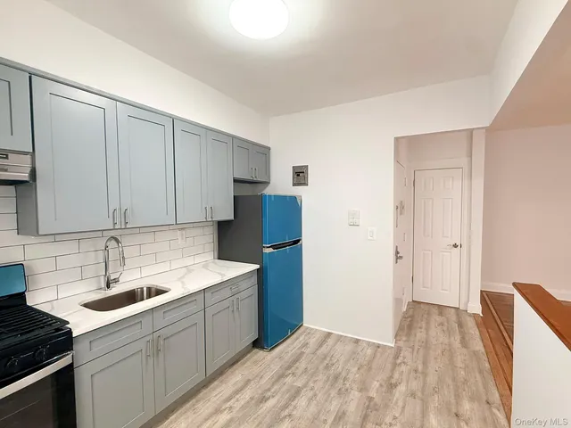 a kitchen with a sink cabinets and wooden floor