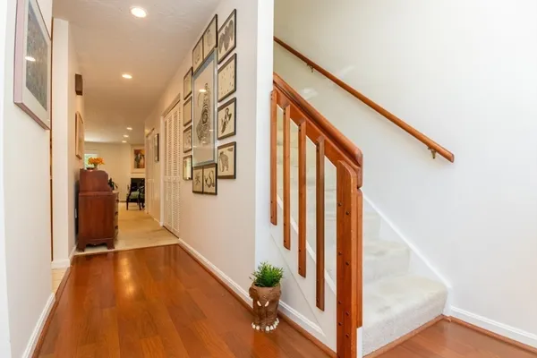 a view of a hallway with wooden floor and staircase