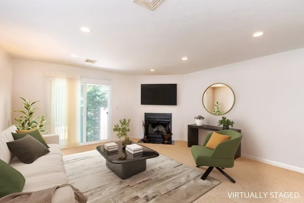 a living room with fireplace furniture and a large window