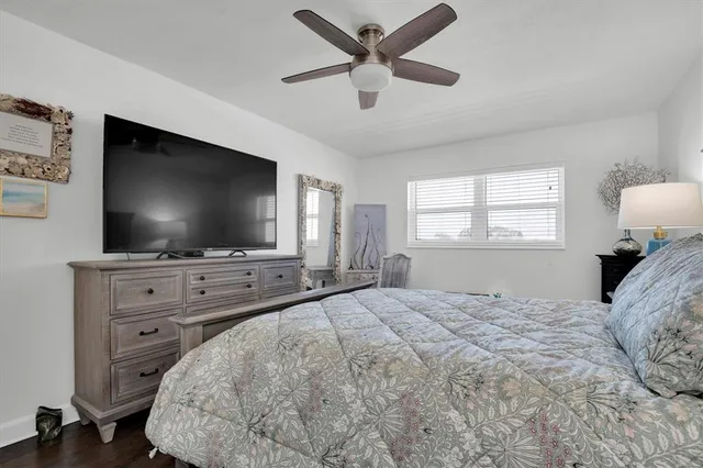 a bedroom with a bed and a flat screen tv on dresser