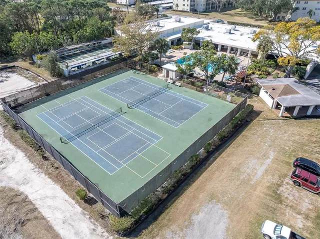 a view of a tennis ground with large trees