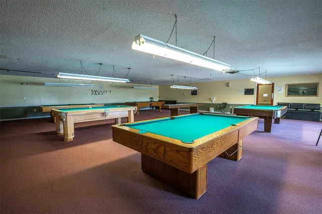 a room with pool table and chairs