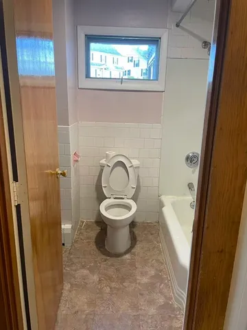 a spacious bathroom with a toilet and a shower
