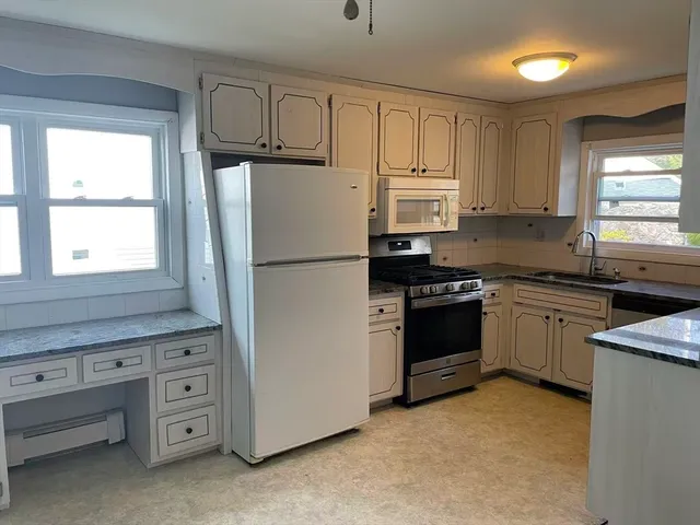 a kitchen with cabinets stainless steel appliances and window