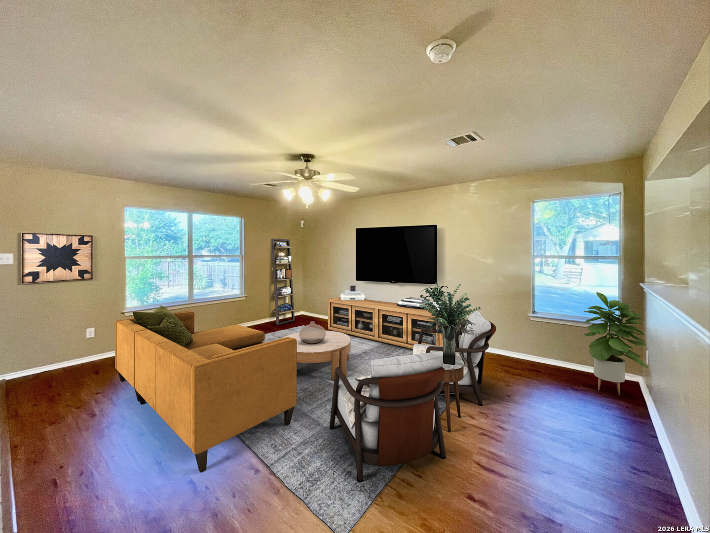 a living room with furniture flat screen tv and wooden floor
