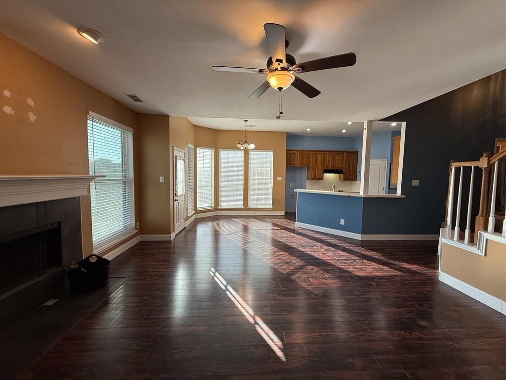 117 Hanover Street Grand Prairie, TX 75052 - Photo 2 of 40 a view of a livingroom with wooden floor a ceiling fan and a kitchen