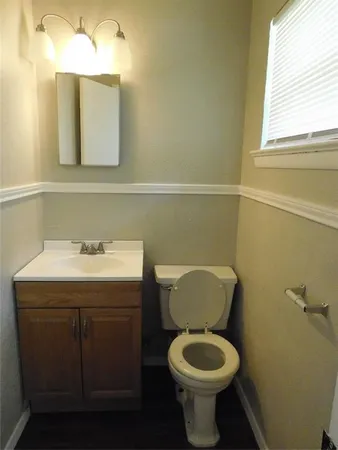 a bathroom with a toilet sink and mirror