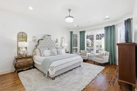 a spacious bedroom with a bed a couch and large window