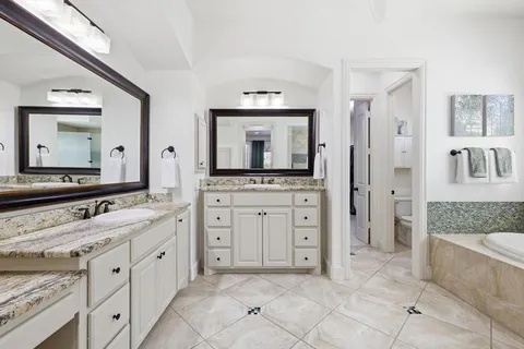 a spacious bathroom with a granite countertop sink mirror and a