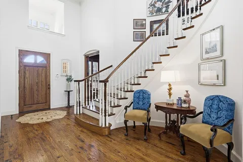 a living room with couches and a dining table with wooden floor