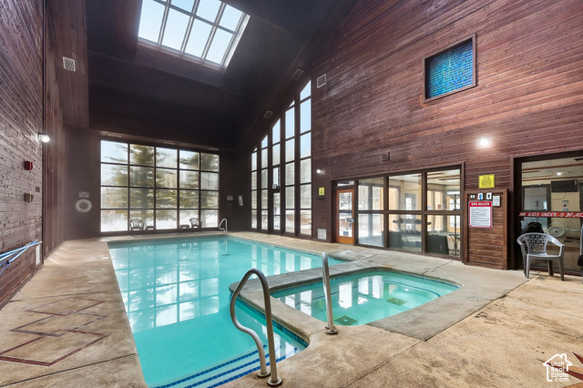 150 Ridgeview Street Brian Head, UT 84719 - Photo 29 of 43 Indoor swimming pool with an integrated spa, vaulted wood-paneled ceilings, and expansive fenestration