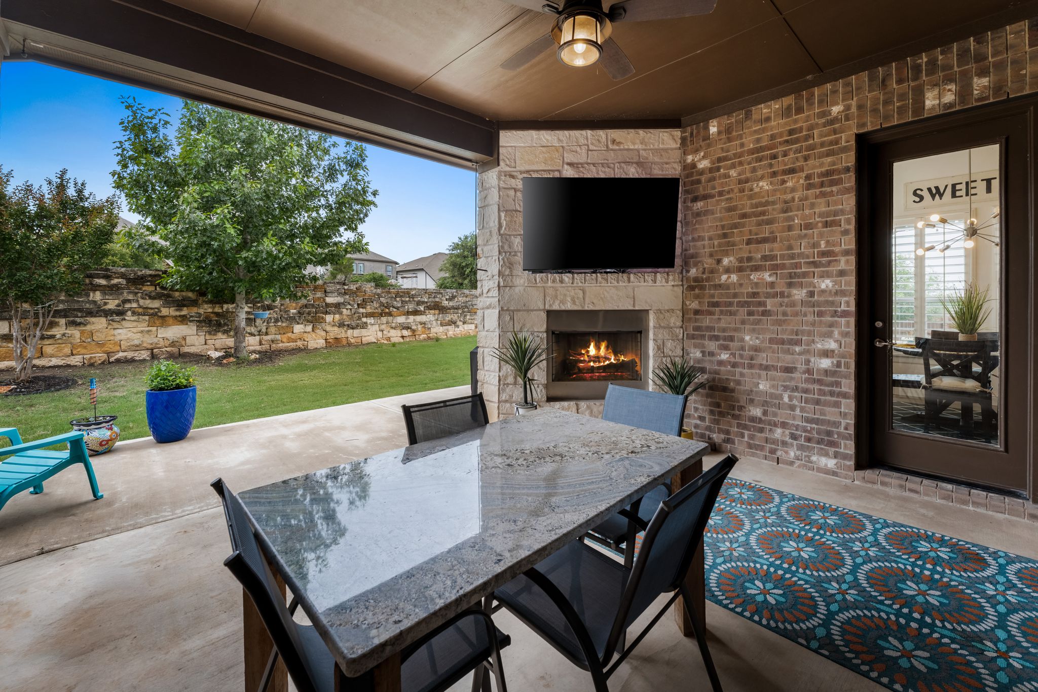 140 Waterloo Cove Georgetown, TX 78628 - Photo 39 of 40 An inviting outdoor living space features a cozy fireplace and a dedicated area for dining and relaxation.