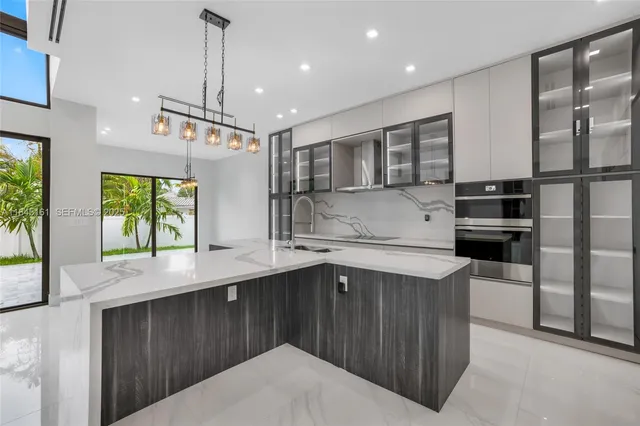 a kitchen with counter top space and windows