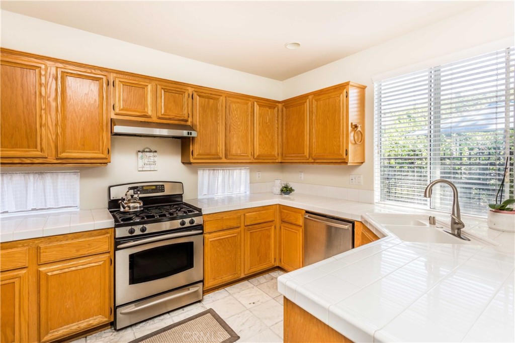 111 Colony Way Aliso Viejo, CA 92656 - Photo 11 of 29 a kitchen with granite countertop a sink stainless steel appliances and cabinets