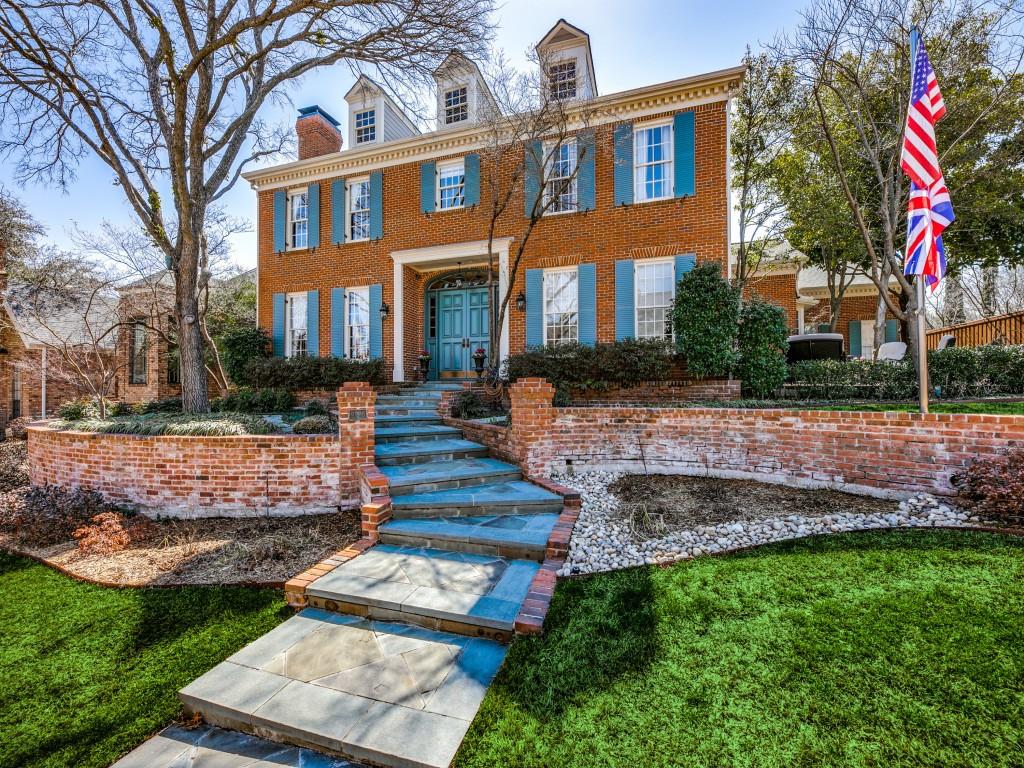a front view of a house with a garden and tree