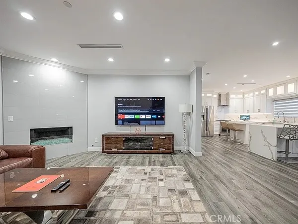 a living room with stainless steel appliances furniture a rug and a view