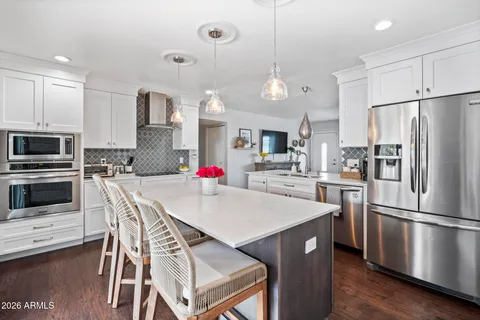 a kitchen with stainless steel appliances a stove a sink refrigerator and a refrigerator