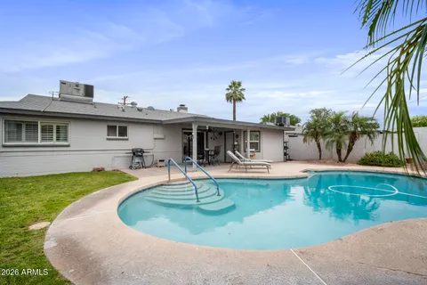 a swimming pool with outdoor seating and plants