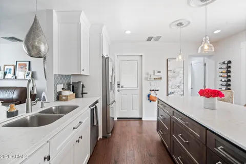 a kitchen with stainless steel appliances a sink a stove a refrigerator and cabinets