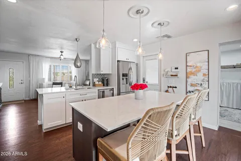a very nice looking dining room with kitchen island wooden floor and white appliances