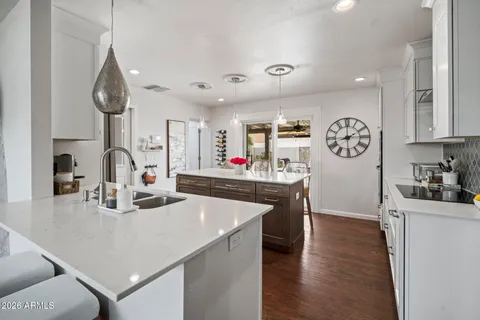 a kitchen with stainless steel appliances granite countertop a sink dishwasher and a stove with wooden floor
