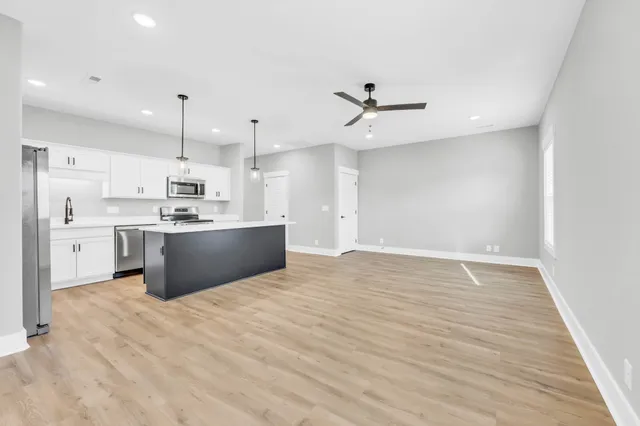 a view of kitchen with kitchen island a sink stainless steel appliances and cabinets