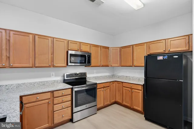 a kitchen with stainless steel appliances granite countertop a refrigerator and a sink