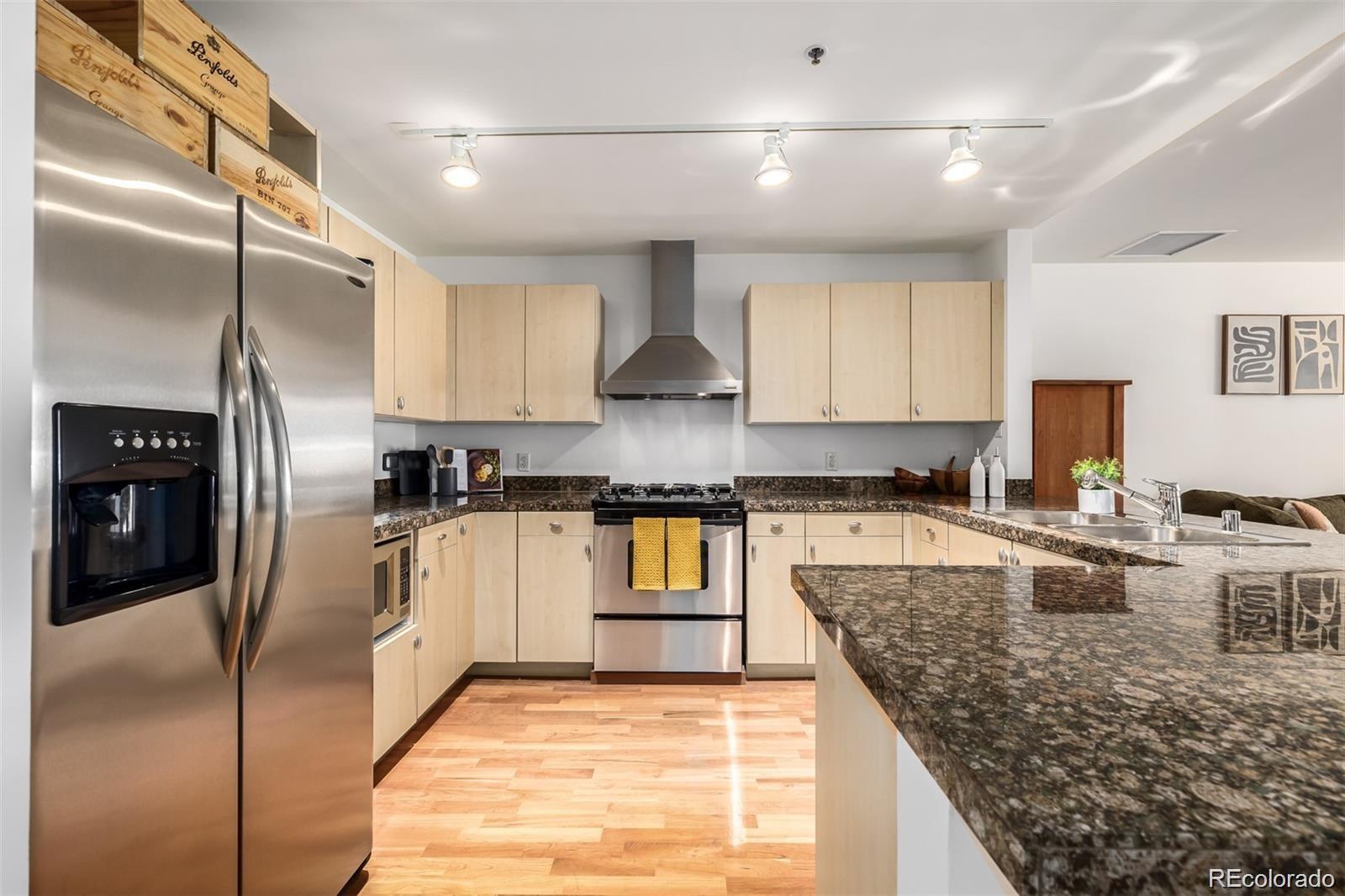 1560 Blake Street, Unit 810 Denver, CO 80202 - Photo 16 of 48 a kitchen with stainless steel appliances granite countertop a refrigerator a stove and a sink
