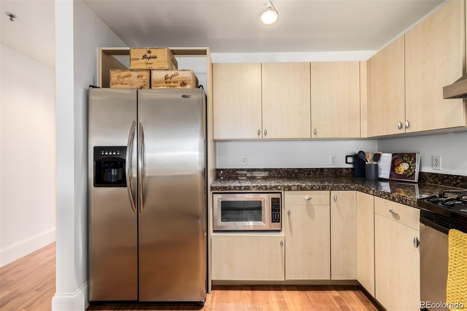 1560 Blake Street, Unit 810 Denver, CO 80202 - Photo 19 of 48 a kitchen with a refrigerator sink and cabinets