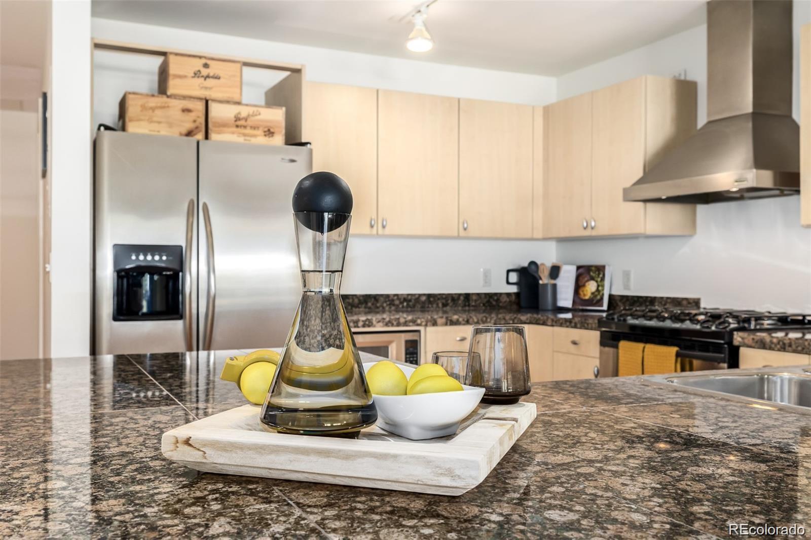 1560 Blake Street, Unit 810 Denver, CO 80202 - Photo 22 of 48 a kitchen with a refrigerator dining table and chairs