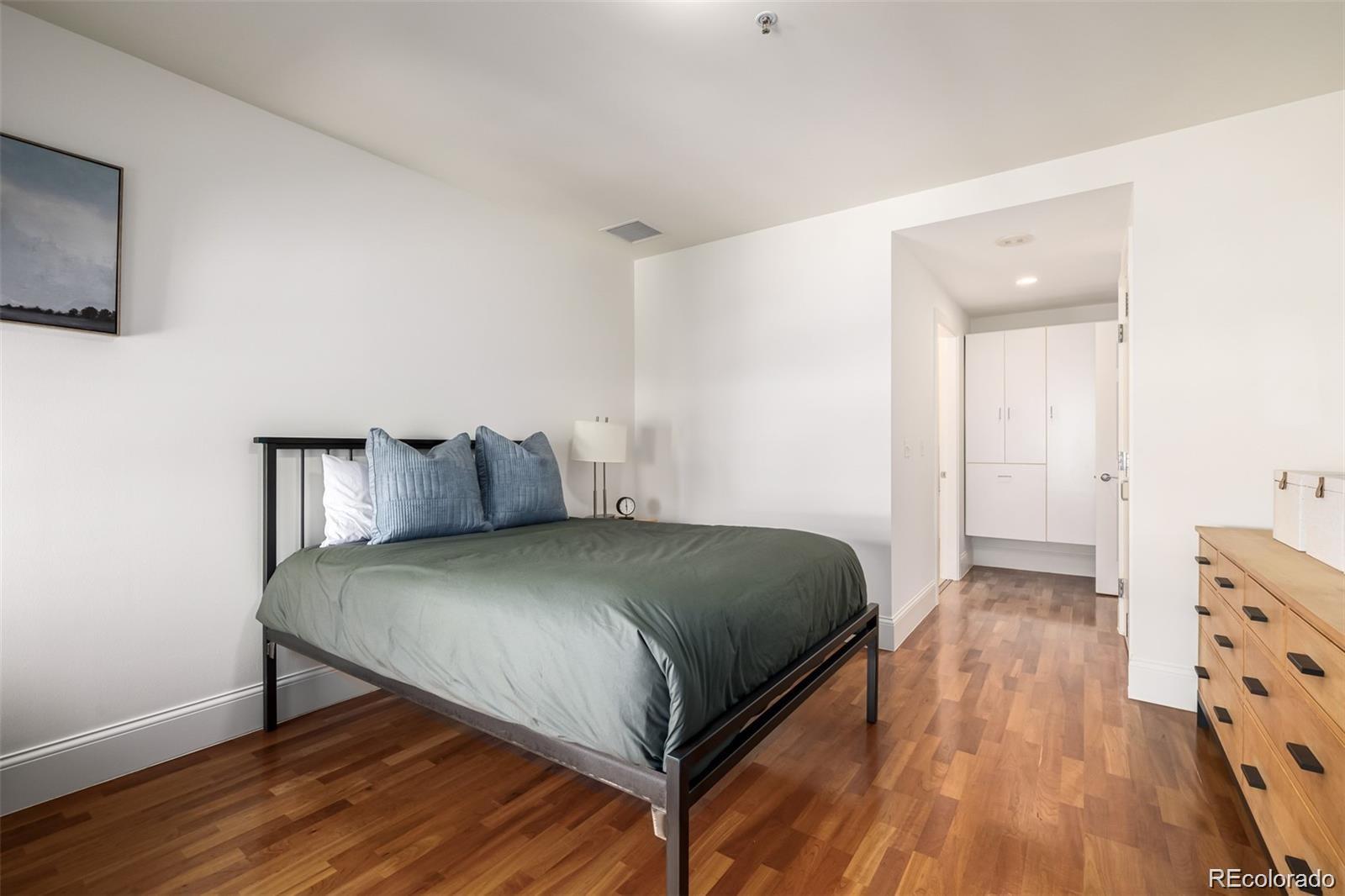1560 Blake Street, Unit 810 Denver, CO 80202 - Photo 24 of 48 a bedroom with a bed and wooden floor