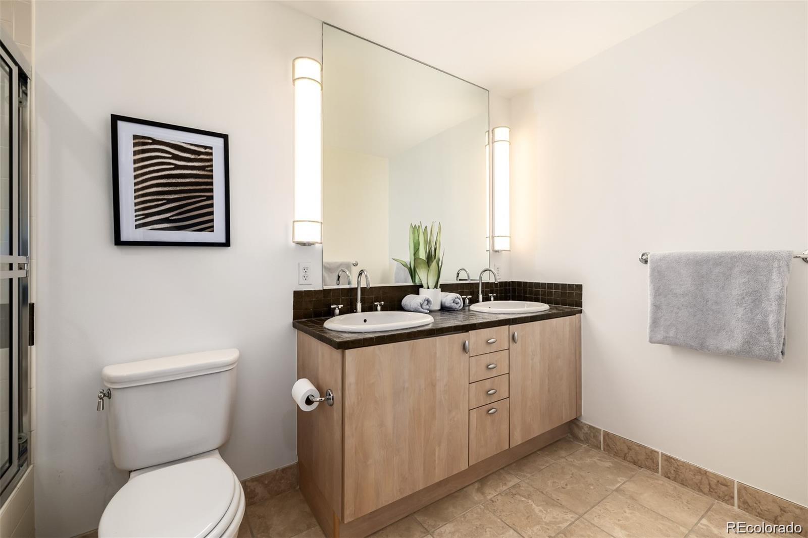 1560 Blake Street, Unit 810 Denver, CO 80202 - Photo 28 of 48 a bathroom with a toilet a sink and mirror