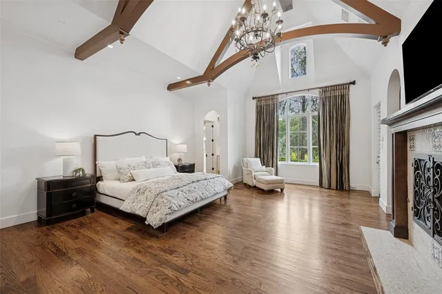 a bedroom with a bed wooden floor and flat screen tv
