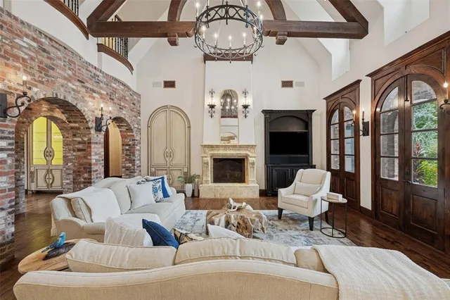 a living room with furniture a fireplace and a chandelier