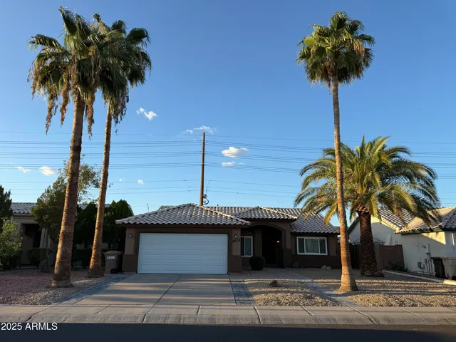 a front view of a house with yard and palm tree