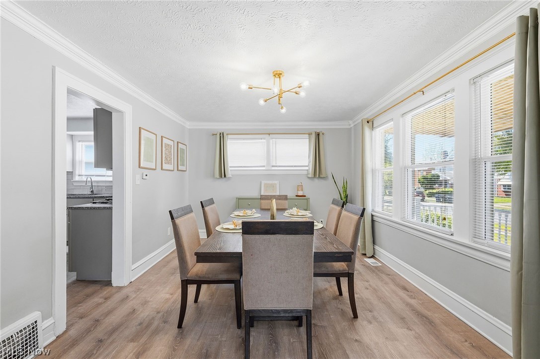 3386 Sylvanhurst Road Cleveland Heights, OH 44112 - Photo 11 of 46 Spacious room featuring wood-finish flooring, crown molding, and a modern sputnik chandelier