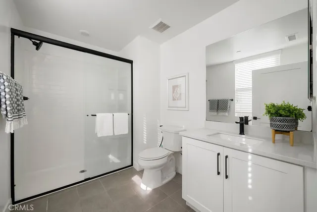 a bathroom with a granite countertop sink a toilet and shower