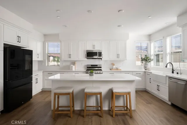 a kitchen with a dining table chairs and refrigerator