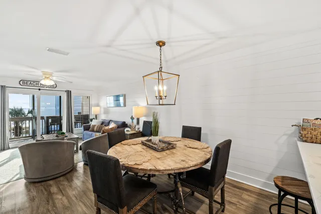 a kitchen with stainless steel appliances a white table a refrigerator and microwave