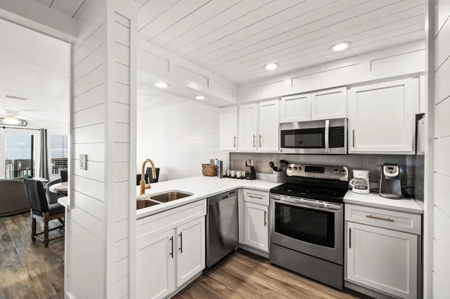 a kitchen with stainless steel appliances white cabinets and white appliances